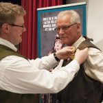 Nytillträdde ordförande för Jägareförbundet Kronoberg Frederik Kjellson kragslår sin företrädare Lennart Haraldsson med länsförbundets förtjänstmedalj i guld. Foto: Jan Henricson