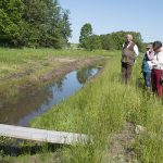 Årets våtmarksstipendiat Peter Feuerbach är en nytänkare. Vid Hushållningssällskapets anläggning söder om Halmstad utvecklar han nya metoder för att använda våtmarker som naturens eget reningsverk. Lyssnar gör Våtmarksfondens ordförande Lars Ingelmark, längst till vänster av åhörarna. Foto: Jan Henricson